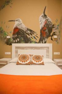 ein Schlafzimmer mit einem Bett mit zwei Vögeln an der Wand in der Unterkunft Cumbres de los Picos Apartamento Treparriscos in Poo de Cabrales