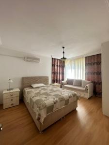 ein Schlafzimmer mit einem Bett und einem Sofa in der Unterkunft Daire Plaja Sadece 700 M Uzaklıkta in Antalya