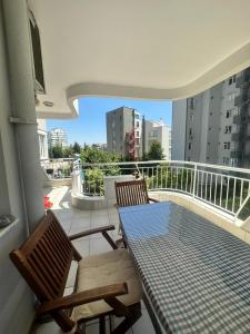 einen Balkon mit 2 Stühlen und einem Tisch auf dem Balkon in der Unterkunft Daire Plaja Sadece 700 M Uzaklıkta in Antalya