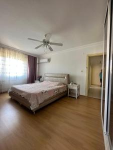 Schlafzimmer mit einem Bett und einem Deckenventilator in der Unterkunft Daire Plaja Sadece 700 M Uzaklıkta in Antalya