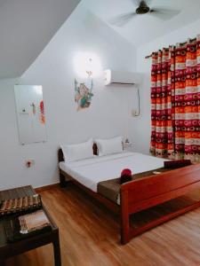 a bedroom with a bed and a table in a room at Ronne's 2Bhk vacation rental near Baga Beach in Calangute
