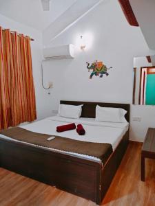 a bedroom with a large bed with a wooden floor at Ronne's 2Bhk vacation rental near Baga Beach in Calangute