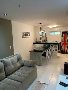a living room with a couch and a kitchen at hihome - Mandai Flat in Cabo Frio
