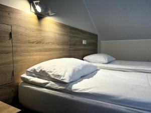 a bed with two pillows on it in a room at SIEDEM WYDM in Rowy +28 photos