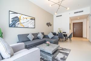a living room with a couch and a table at Al Meydan - Prime Views 1BR in Al Meydan in Dubai