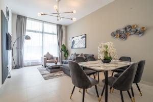 a living room with a table and chairs at Al Meydan - Prime Views 1BR in Al Meydan in Dubai