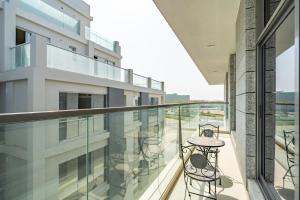 a balcony with a table and chairs on a building at Al Meydan - Prime Views 1BR in Al Meydan in Dubai