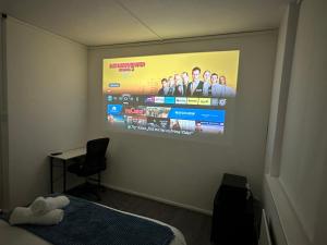 a room with a projection screen on the wall at Unique Double Bedroom in London