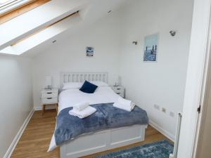 a white bedroom with a bed and a window at Little Rondeval in Totnes