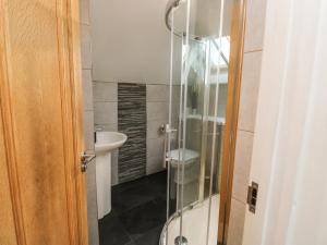 a glass shower in a bathroom with a sink at Little Rondeval in Totnes