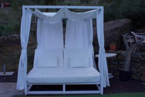 - un lit à baldaquin blanc avec des rideaux blancs sur la terrasse dans l'établissement Mogán Natural, à Mogán