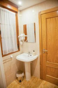 a bathroom with a sink and a mirror at Cumbres de los Picos Apartamento La Yedra in Poo de Cabrales