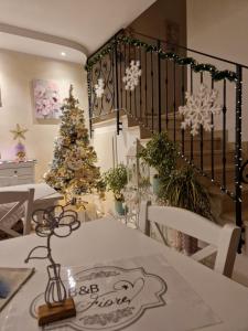 B&B Fiore في Ganfardine: غرفة طعام مع شجرة عيد الميلاد وطاولة