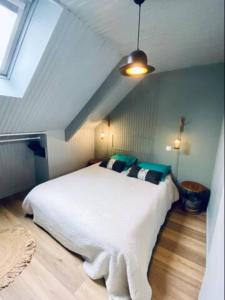 パンポルにあるAppartement - Boutiqueの緑の枕が付いた大きな白いベッドのある寝室