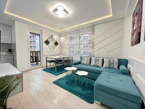uma sala de estar com um sofá azul e uma mesa em Apartmani SLEEP&JOY em Zlatibor