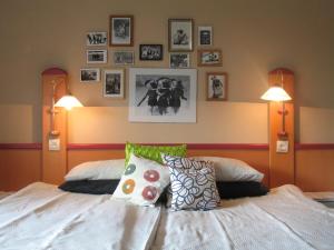 a bedroom with a bed with pictures on the wall at Willa Pod Aniołem in Szczyrk