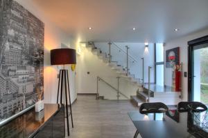 - un salon avec des escaliers, une table et des chaises dans l'établissement Villa contemporaine Mandarine, à Palaiseau