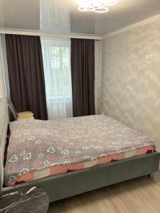 a bedroom with a bed in a room with a window at Квартира для приятного отдыха! Удобства и комфорт! in Tiraspol