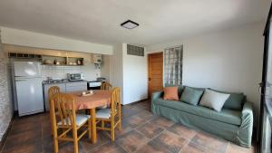 a living room with a couch and a table at Mirada al Champaqui - Departamento de Montaña in Villa Yacanto