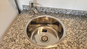 a stainless steel sink in a granite counter top at Mirada al Champaqui - Departamento de Montaña in Villa Yacanto +75 photos