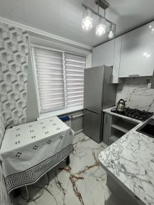 a small kitchen with a counter and a refrigerator at Квартира для приятного отдыха! Удобства и комфорт! in Tiraspol