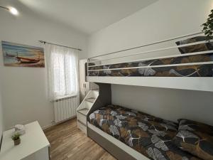 une chambre avec deux lits superposés et une fenêtre dans l'établissement Ca' Donin - Centro storico, à Chioggia