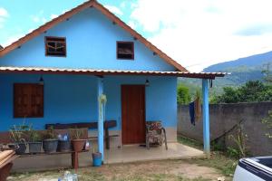 una casa azul con un banco delante en Chalé Córrego Comprido, en Divisa