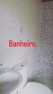 y baño con aseo blanco y lavamanos. en Chalé Córrego Comprido, en Divisa