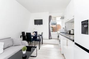 ein weißes Wohnzimmer mit einem Sofa und einem Tisch in der Unterkunft Strand Central Apartments in London