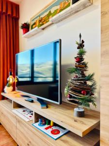 a christmas tree on a entertainment center with a television at Monte Oiz con wifi y parking gratis in Sierra Nevada