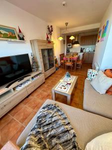 a living room with a large flat screen tv at Monte Oiz con wifi y parking gratis in Sierra Nevada