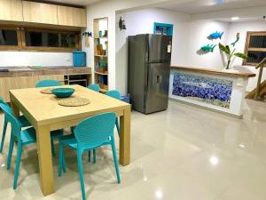 cocina con mesa, sillas y nevera en La Casita Azul Boutique Villa, en Providencia