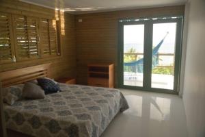 a bedroom with a bed and a large window at La Casita Azul Boutique Villa in Providencia