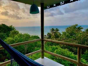 un balcón con hamaca y vistas al océano en La Casita Azul Boutique Villa, en Providencia