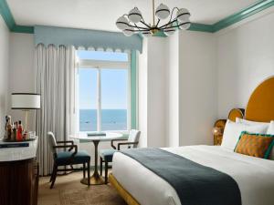 ロサンゼルスにあるザ ジョージアン ホテルのベッドルーム1室(ベッド1台、テーブル、窓付)