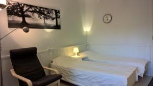 - une chambre avec un lit, une chaise et un réveil dans l'établissement Aparthotel LeviStar, à Levi