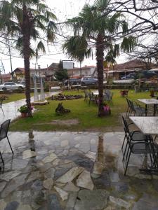 a park with tables and chairs and palm trees at ΣΕΤΣΚΟΣ ΖΗΣΗΣ in Kato Loutraki