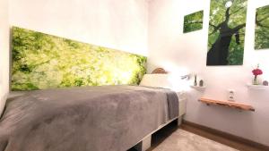1 dormitorio con 1 cama con una pintura en la pared en Ferienwohnung Abenddämmerung Hahnenklee, en Hahnenklee-Bockswiese