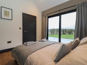 a bedroom with a large bed with a large window at Skylark in Huggate