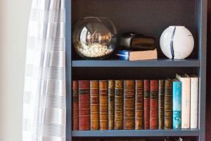 een boekenplank gevuld met boeken en een kom popcorn bij The Beach House at Sandgate by Bloom Stays in Sandgate