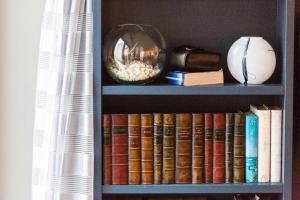 a book shelf filled with books and a bowl of popcorn at The Beach House at Sandgate by Bloom Stays in Sandgate