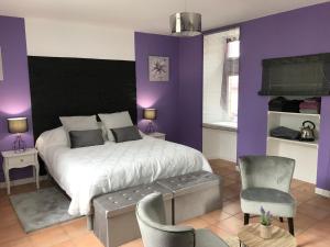 ein Schlafzimmer mit einem großen Bett und lila Wänden in der Unterkunft Chambre d'hôte Lavande - Le soleil des Cévennes in Saint-Jean-du-Gard