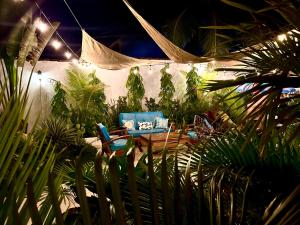 two chairs and a table in a garden at night at Hotel Tranquilo in Las Peñitas