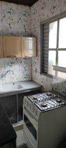 cocina con estufa blanca y ventana en Kitnet mobiliada, quarto, banheiro, cozinha americana, en Luziânia