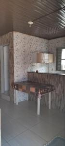 una cocina con un banco de madera en una habitación en Kitnet mobiliada, quarto, banheiro, cozinha americana, en Luziânia