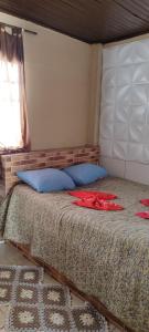Un dormitorio con una cama con dos camisas rojas. en Kitnet mobiliada, quarto, banheiro, cozinha americana, en Luziânia