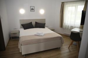 1 dormitorio con 1 cama blanca grande y escritorio en Pensiunea Zbor, en Cluj-Napoca