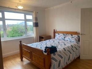 a bedroom with a bed and a large window at Spacious home near city hospital in Nottingham