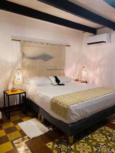 een slaapkamer met een groot bed en 2 lampen bij Hostal Patio del Río in Cali