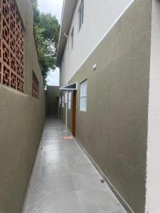 un couloir vide d'un bâtiment situé à côté d'un bâtiment dans l'établissement Casa novinha - Praia Grande - Mirim - 3 quadras da Praia Wi-Fi, à Praia Grande